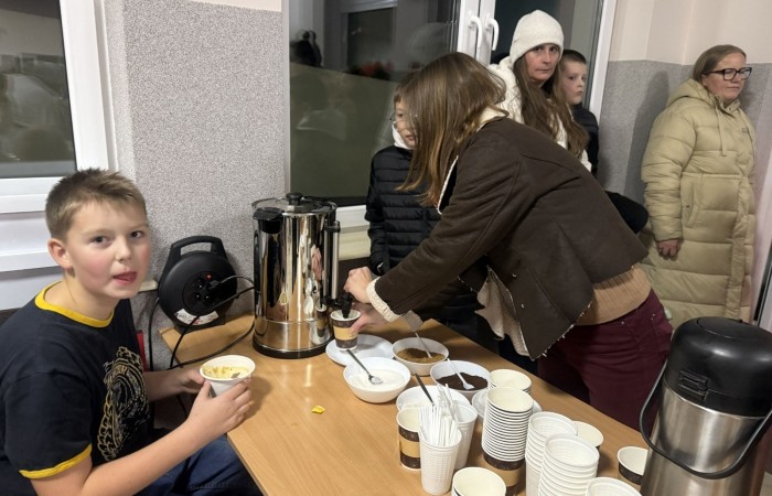 O godzinie 17:00 pod szkołą rozpoczęła się impreza, która zgromadziła około 200 osób. Szkoła została podświetlona na czerwono, co symbolizowało naszą jedność w walce z przemocą. Był to akcent podsumowujący nasze wcześ iej sze  działania w ramach Kampanii Ogólnopolskiej „Dzieciństwo bez Przemocy”. Od października uczniowie uczestniczyli w lekcjach online przygotowanych przez Fundację Dajemy Dzieciom Siłę. Rodzice również zostali objęci wsparciem w postaci webinaru online ww. fudacji.
Uczestnicy mogli wziąć udział w wspólnym śpiewaniu, quizie wiedzy o przemocy oraz tworzeniu „kamieni mocy” – symboli pozytywnej energii i wsparcia. Dodatkowo, w ramach konkursów, przyznano nagrody ufundowane przez Urząd Miejski w Pasłęku.
Ten cudowny czas umilił nam smaczny poczęstunek, w tym grochówka, pizza i ciasta, gorąca kawa i herbatka przygotowany przez panie kucharki i rodziców.
W wydarzeniu uczestniczyli również zaproszeni goście, w tym Burmistrz Pasłęka – pani Elżbieta Wasiuk,  podinspektor KP Pasłęk – pani Agnieszka Bielewicz - Piechowiak oraz przedstawiciel Kuratorium Oświaty w Elblągu – pani Teresa Bednarz, którzy wspierają nasze działania. Ich obecność była dowodem na to, jak ważna jest współpraca lokalnej społeczności w walce z przemocą wobec dzieci. Dziękujemy wszystkim, którzy wzięli udział w tym wyjątkowym dniu oraz przyczynili się do jego organizacji. Razem możemy stworzyć bezpieczne i przyjazne środowisko dla naszych dzieci!
