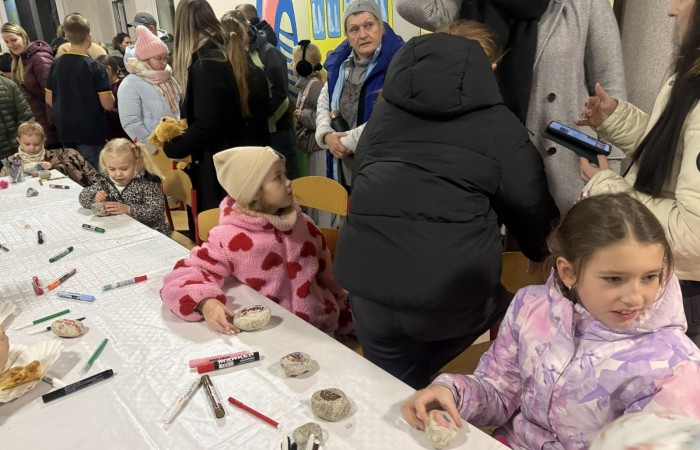 O godzinie 17:00 pod szkołą rozpoczęła się impreza, która zgromadziła około 200 osób. Szkoła została podświetlona na czerwono, co symbolizowało naszą jedność w walce z przemocą. Był to akcent podsumowujący nasze wcześ iej sze  działania w ramach Kampanii Ogólnopolskiej „Dzieciństwo bez Przemocy”. Od października uczniowie uczestniczyli w lekcjach online przygotowanych przez Fundację Dajemy Dzieciom Siłę. Rodzice również zostali objęci wsparciem w postaci webinaru online ww. fudacji.
Uczestnicy mogli wziąć udział w wspólnym śpiewaniu, quizie wiedzy o przemocy oraz tworzeniu „kamieni mocy” – symboli pozytywnej energii i wsparcia. Dodatkowo, w ramach konkursów, przyznano nagrody ufundowane przez Urząd Miejski w Pasłęku.
Ten cudowny czas umilił nam smaczny poczęstunek, w tym grochówka, pizza i ciasta, gorąca kawa i herbatka przygotowany przez panie kucharki i rodziców.
W wydarzeniu uczestniczyli również zaproszeni goście, w tym Burmistrz Pasłęka – pani Elżbieta Wasiuk,  podinspektor KP Pasłęk – pani Agnieszka Bielewicz - Piechowiak oraz przedstawiciel Kuratorium Oświaty w Elblągu – pani Teresa Bednarz, którzy wspierają nasze działania. Ich obecność była dowodem na to, jak ważna jest współpraca lokalnej społeczności w walce z przemocą wobec dzieci. Dziękujemy wszystkim, którzy wzięli udział w tym wyjątkowym dniu oraz przyczynili się do jego organizacji. Razem możemy stworzyć bezpieczne i przyjazne środowisko dla naszych dzieci!
