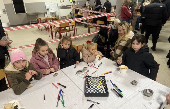 O godzinie 17:00 pod szkołą rozpoczęła się impreza, która zgromadziła około 200 osób. Szkoła została podświetlona na czerwono, co symbolizowało naszą jedność w walce z przemocą. Był to akcent podsumowujący nasze wcześ iej sze  działania w ramach Kampanii Ogólnopolskiej „Dzieciństwo bez Przemocy”. Od października uczniowie uczestniczyli w lekcjach online przygotowanych przez Fundację Dajemy Dzieciom Siłę. Rodzice również zostali objęci wsparciem w postaci webinaru online ww. fudacji.
Uczestnicy mogli wziąć udział w wspólnym śpiewaniu, quizie wiedzy o przemocy oraz tworzeniu „kamieni mocy” – symboli pozytywnej energii i wsparcia. Dodatkowo, w ramach konkursów, przyznano nagrody ufundowane przez Urząd Miejski w Pasłęku.
Ten cudowny czas umilił nam smaczny poczęstunek, w tym grochówka, pizza i ciasta, gorąca kawa i herbatka przygotowany przez panie kucharki i rodziców.
W wydarzeniu uczestniczyli również zaproszeni goście, w tym Burmistrz Pasłęka – pani Elżbieta Wasiuk,  podinspektor KP Pasłęk – pani Agnieszka Bielewicz - Piechowiak oraz przedstawiciel Kuratorium Oświaty w Elblągu – pani Teresa Bednarz, którzy wspierają nasze działania. Ich obecność była dowodem na to, jak ważna jest współpraca lokalnej społeczności w walce z przemocą wobec dzieci. Dziękujemy wszystkim, którzy wzięli udział w tym wyjątkowym dniu oraz przyczynili się do jego organizacji. Razem możemy stworzyć bezpieczne i przyjazne środowisko dla naszych dzieci!
