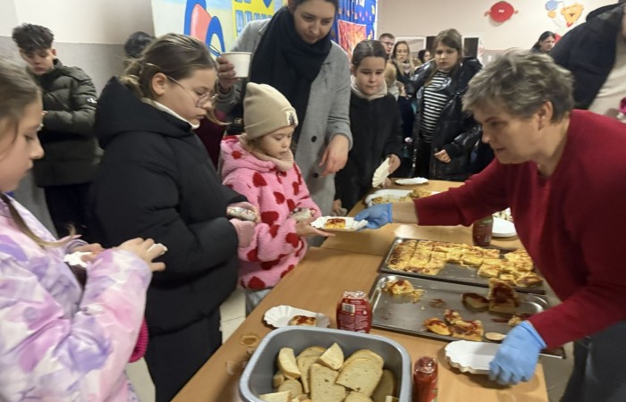 O godzinie 17:00 pod szkołą rozpoczęła się impreza, która zgromadziła około 200 osób. Szkoła została podświetlona na czerwono, co symbolizowało naszą jedność w walce z przemocą. Był to akcent podsumowujący nasze wcześ iej sze  działania w ramach Kampanii Ogólnopolskiej „Dzieciństwo bez Przemocy”. Od października uczniowie uczestniczyli w lekcjach online przygotowanych przez Fundację Dajemy Dzieciom Siłę. Rodzice również zostali objęci wsparciem w postaci webinaru online ww. fudacji.
Uczestnicy mogli wziąć udział w wspólnym śpiewaniu, quizie wiedzy o przemocy oraz tworzeniu „kamieni mocy” – symboli pozytywnej energii i wsparcia. Dodatkowo, w ramach konkursów, przyznano nagrody ufundowane przez Urząd Miejski w Pasłęku.
Ten cudowny czas umilił nam smaczny poczęstunek, w tym grochówka, pizza i ciasta, gorąca kawa i herbatka przygotowany przez panie kucharki i rodziców.
W wydarzeniu uczestniczyli również zaproszeni goście, w tym Burmistrz Pasłęka – pani Elżbieta Wasiuk,  podinspektor KP Pasłęk – pani Agnieszka Bielewicz - Piechowiak oraz przedstawiciel Kuratorium Oświaty w Elblągu – pani Teresa Bednarz, którzy wspierają nasze działania. Ich obecność była dowodem na to, jak ważna jest współpraca lokalnej społeczności w walce z przemocą wobec dzieci. Dziękujemy wszystkim, którzy wzięli udział w tym wyjątkowym dniu oraz przyczynili się do jego organizacji. Razem możemy stworzyć bezpieczne i przyjazne środowisko dla naszych dzieci!

