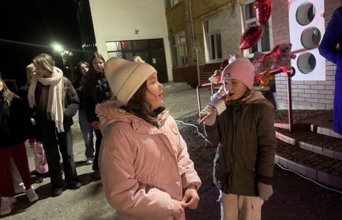 O godzinie 17:00 pod szkołą rozpoczęła się impreza, która zgromadziła około 200 osób. Szkoła została podświetlona na czerwono, co symbolizowało naszą jedność w walce z przemocą. Był to akcent podsumowujący nasze wcześ iej sze  działania w ramach Kampanii Ogólnopolskiej „Dzieciństwo bez Przemocy”. Od października uczniowie uczestniczyli w lekcjach online przygotowanych przez Fundację Dajemy Dzieciom Siłę. Rodzice również zostali objęci wsparciem w postaci webinaru online ww. fudacji.
Uczestnicy mogli wziąć udział w wspólnym śpiewaniu, quizie wiedzy o przemocy oraz tworzeniu „kamieni mocy” – symboli pozytywnej energii i wsparcia. Dodatkowo, w ramach konkursów, przyznano nagrody ufundowane przez Urząd Miejski w Pasłęku.
Ten cudowny czas umilił nam smaczny poczęstunek, w tym grochówka, pizza i ciasta, gorąca kawa i herbatka przygotowany przez panie kucharki i rodziców.
W wydarzeniu uczestniczyli również zaproszeni goście, w tym Burmistrz Pasłęka – pani Elżbieta Wasiuk,  podinspektor KP Pasłęk – pani Agnieszka Bielewicz - Piechowiak oraz przedstawiciel Kuratorium Oświaty w Elblągu – pani Teresa Bednarz, którzy wspierają nasze działania. Ich obecność była dowodem na to, jak ważna jest współpraca lokalnej społeczności w walce z przemocą wobec dzieci. Dziękujemy wszystkim, którzy wzięli udział w tym wyjątkowym dniu oraz przyczynili się do jego organizacji. Razem możemy stworzyć bezpieczne i przyjazne środowisko dla naszych dzieci!
