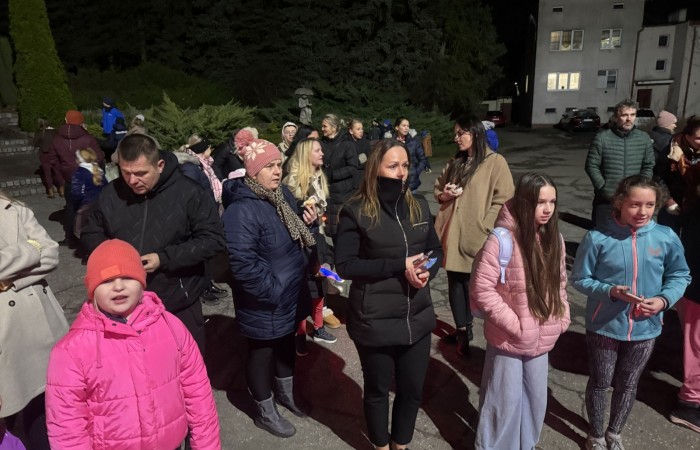 O godzinie 17:00 pod szkołą rozpoczęła się impreza, która zgromadziła około 200 osób. Szkoła została podświetlona na czerwono, co symbolizowało naszą jedność w walce z przemocą. Był to akcent podsumowujący nasze wcześ iej sze  działania w ramach Kampanii Ogólnopolskiej „Dzieciństwo bez Przemocy”. Od października uczniowie uczestniczyli w lekcjach online przygotowanych przez Fundację Dajemy Dzieciom Siłę. Rodzice również zostali objęci wsparciem w postaci webinaru online ww. fudacji.
Uczestnicy mogli wziąć udział w wspólnym śpiewaniu, quizie wiedzy o przemocy oraz tworzeniu „kamieni mocy” – symboli pozytywnej energii i wsparcia. Dodatkowo, w ramach konkursów, przyznano nagrody ufundowane przez Urząd Miejski w Pasłęku.
Ten cudowny czas umilił nam smaczny poczęstunek, w tym grochówka, pizza i ciasta, gorąca kawa i herbatka przygotowany przez panie kucharki i rodziców.
W wydarzeniu uczestniczyli również zaproszeni goście, w tym Burmistrz Pasłęka – pani Elżbieta Wasiuk,  podinspektor KP Pasłęk – pani Agnieszka Bielewicz - Piechowiak oraz przedstawiciel Kuratorium Oświaty w Elblągu – pani Teresa Bednarz, którzy wspierają nasze działania. Ich obecność była dowodem na to, jak ważna jest współpraca lokalnej społeczności w walce z przemocą wobec dzieci. Dziękujemy wszystkim, którzy wzięli udział w tym wyjątkowym dniu oraz przyczynili się do jego organizacji. Razem możemy stworzyć bezpieczne i przyjazne środowisko dla naszych dzieci!
