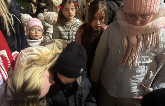 O godzinie 17:00 pod szkołą rozpoczęła się impreza, która zgromadziła około 200 osób. Szkoła została podświetlona na czerwono, co symbolizowało naszą jedność w walce z przemocą. Był to akcent podsumowujący nasze wcześ iej sze  działania w ramach Kampanii Ogólnopolskiej „Dzieciństwo bez Przemocy”. Od października uczniowie uczestniczyli w lekcjach online przygotowanych przez Fundację Dajemy Dzieciom Siłę. Rodzice również zostali objęci wsparciem w postaci webinaru online ww. fudacji.
Uczestnicy mogli wziąć udział w wspólnym śpiewaniu, quizie wiedzy o przemocy oraz tworzeniu „kamieni mocy” – symboli pozytywnej energii i wsparcia. Dodatkowo, w ramach konkursów, przyznano nagrody ufundowane przez Urząd Miejski w Pasłęku.
Ten cudowny czas umilił nam smaczny poczęstunek, w tym grochówka, pizza i ciasta, gorąca kawa i herbatka przygotowany przez panie kucharki i rodziców.
W wydarzeniu uczestniczyli również zaproszeni goście, w tym Burmistrz Pasłęka – pani Elżbieta Wasiuk,  podinspektor KP Pasłęk – pani Agnieszka Bielewicz - Piechowiak oraz przedstawiciel Kuratorium Oświaty w Elblągu – pani Teresa Bednarz, którzy wspierają nasze działania. Ich obecność była dowodem na to, jak ważna jest współpraca lokalnej społeczności w walce z przemocą wobec dzieci. Dziękujemy wszystkim, którzy wzięli udział w tym wyjątkowym dniu oraz przyczynili się do jego organizacji. Razem możemy stworzyć bezpieczne i przyjazne środowisko dla naszych dzieci!
