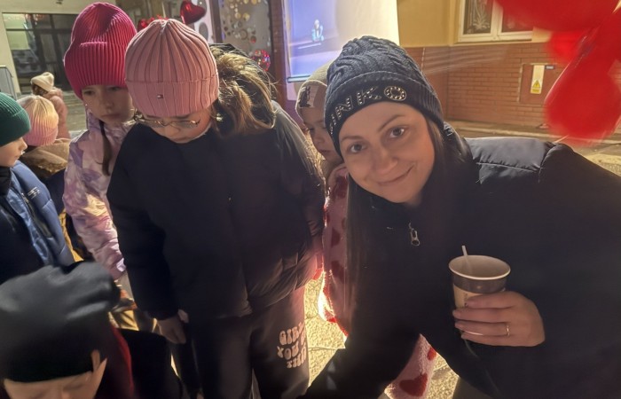 O godzinie 17:00 pod szkołą rozpoczęła się impreza, która zgromadziła około 200 osób. Szkoła została podświetlona na czerwono, co symbolizowało naszą jedność w walce z przemocą. Był to akcent podsumowujący nasze wcześ iej sze  działania w ramach Kampanii Ogólnopolskiej „Dzieciństwo bez Przemocy”. Od października uczniowie uczestniczyli w lekcjach online przygotowanych przez Fundację Dajemy Dzieciom Siłę. Rodzice również zostali objęci wsparciem w postaci webinaru online ww. fudacji.
Uczestnicy mogli wziąć udział w wspólnym śpiewaniu, quizie wiedzy o przemocy oraz tworzeniu „kamieni mocy” – symboli pozytywnej energii i wsparcia. Dodatkowo, w ramach konkursów, przyznano nagrody ufundowane przez Urząd Miejski w Pasłęku.
Ten cudowny czas umilił nam smaczny poczęstunek, w tym grochówka, pizza i ciasta, gorąca kawa i herbatka przygotowany przez panie kucharki i rodziców.
W wydarzeniu uczestniczyli również zaproszeni goście, w tym Burmistrz Pasłęka – pani Elżbieta Wasiuk,  podinspektor KP Pasłęk – pani Agnieszka Bielewicz - Piechowiak oraz przedstawiciel Kuratorium Oświaty w Elblągu – pani Teresa Bednarz, którzy wspierają nasze działania. Ich obecność była dowodem na to, jak ważna jest współpraca lokalnej społeczności w walce z przemocą wobec dzieci. Dziękujemy wszystkim, którzy wzięli udział w tym wyjątkowym dniu oraz przyczynili się do jego organizacji. Razem możemy stworzyć bezpieczne i przyjazne środowisko dla naszych dzieci!
