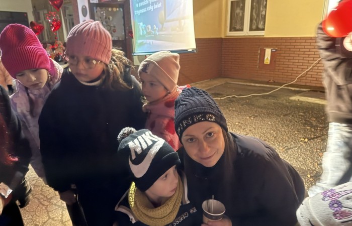 O godzinie 17:00 pod szkołą rozpoczęła się impreza, która zgromadziła około 200 osób. Szkoła została podświetlona na czerwono, co symbolizowało naszą jedność w walce z przemocą. Był to akcent podsumowujący nasze wcześ iej sze  działania w ramach Kampanii Ogólnopolskiej „Dzieciństwo bez Przemocy”. Od października uczniowie uczestniczyli w lekcjach online przygotowanych przez Fundację Dajemy Dzieciom Siłę. Rodzice również zostali objęci wsparciem w postaci webinaru online ww. fudacji.
Uczestnicy mogli wziąć udział w wspólnym śpiewaniu, quizie wiedzy o przemocy oraz tworzeniu „kamieni mocy” – symboli pozytywnej energii i wsparcia. Dodatkowo, w ramach konkursów, przyznano nagrody ufundowane przez Urząd Miejski w Pasłęku.
Ten cudowny czas umilił nam smaczny poczęstunek, w tym grochówka, pizza i ciasta, gorąca kawa i herbatka przygotowany przez panie kucharki i rodziców.
W wydarzeniu uczestniczyli również zaproszeni goście, w tym Burmistrz Pasłęka – pani Elżbieta Wasiuk,  podinspektor KP Pasłęk – pani Agnieszka Bielewicz - Piechowiak oraz przedstawiciel Kuratorium Oświaty w Elblągu – pani Teresa Bednarz, którzy wspierają nasze działania. Ich obecność była dowodem na to, jak ważna jest współpraca lokalnej społeczności w walce z przemocą wobec dzieci. Dziękujemy wszystkim, którzy wzięli udział w tym wyjątkowym dniu oraz przyczynili się do jego organizacji. Razem możemy stworzyć bezpieczne i przyjazne środowisko dla naszych dzieci!
