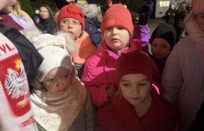 O godzinie 17:00 pod szkołą rozpoczęła się impreza, która zgromadziła około 200 osób. Szkoła została podświetlona na czerwono, co symbolizowało naszą jedność w walce z przemocą. Był to akcent podsumowujący nasze wcześ iej sze  działania w ramach Kampanii Ogólnopolskiej „Dzieciństwo bez Przemocy”. Od października uczniowie uczestniczyli w lekcjach online przygotowanych przez Fundację Dajemy Dzieciom Siłę. Rodzice również zostali objęci wsparciem w postaci webinaru online ww. fudacji.
Uczestnicy mogli wziąć udział w wspólnym śpiewaniu, quizie wiedzy o przemocy oraz tworzeniu „kamieni mocy” – symboli pozytywnej energii i wsparcia. Dodatkowo, w ramach konkursów, przyznano nagrody ufundowane przez Urząd Miejski w Pasłęku.
Ten cudowny czas umilił nam smaczny poczęstunek, w tym grochówka, pizza i ciasta, gorąca kawa i herbatka przygotowany przez panie kucharki i rodziców.
W wydarzeniu uczestniczyli również zaproszeni goście, w tym Burmistrz Pasłęka – pani Elżbieta Wasiuk,  podinspektor KP Pasłęk – pani Agnieszka Bielewicz - Piechowiak oraz przedstawiciel Kuratorium Oświaty w Elblągu – pani Teresa Bednarz, którzy wspierają nasze działania. Ich obecność była dowodem na to, jak ważna jest współpraca lokalnej społeczności w walce z przemocą wobec dzieci. Dziękujemy wszystkim, którzy wzięli udział w tym wyjątkowym dniu oraz przyczynili się do jego organizacji. Razem możemy stworzyć bezpieczne i przyjazne środowisko dla naszych dzieci!
