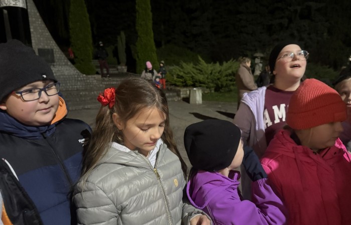 O godzinie 17:00 pod szkołą rozpoczęła się impreza, która zgromadziła około 200 osób. Szkoła została podświetlona na czerwono, co symbolizowało naszą jedność w walce z przemocą. Był to akcent podsumowujący nasze wcześ iej sze  działania w ramach Kampanii Ogólnopolskiej „Dzieciństwo bez Przemocy”. Od października uczniowie uczestniczyli w lekcjach online przygotowanych przez Fundację Dajemy Dzieciom Siłę. Rodzice również zostali objęci wsparciem w postaci webinaru online ww. fudacji.
Uczestnicy mogli wziąć udział w wspólnym śpiewaniu, quizie wiedzy o przemocy oraz tworzeniu „kamieni mocy” – symboli pozytywnej energii i wsparcia. Dodatkowo, w ramach konkursów, przyznano nagrody ufundowane przez Urząd Miejski w Pasłęku.
Ten cudowny czas umilił nam smaczny poczęstunek, w tym grochówka, pizza i ciasta, gorąca kawa i herbatka przygotowany przez panie kucharki i rodziców.
W wydarzeniu uczestniczyli również zaproszeni goście, w tym Burmistrz Pasłęka – pani Elżbieta Wasiuk,  podinspektor KP Pasłęk – pani Agnieszka Bielewicz - Piechowiak oraz przedstawiciel Kuratorium Oświaty w Elblągu – pani Teresa Bednarz, którzy wspierają nasze działania. Ich obecność była dowodem na to, jak ważna jest współpraca lokalnej społeczności w walce z przemocą wobec dzieci. Dziękujemy wszystkim, którzy wzięli udział w tym wyjątkowym dniu oraz przyczynili się do jego organizacji. Razem możemy stworzyć bezpieczne i przyjazne środowisko dla naszych dzieci!
