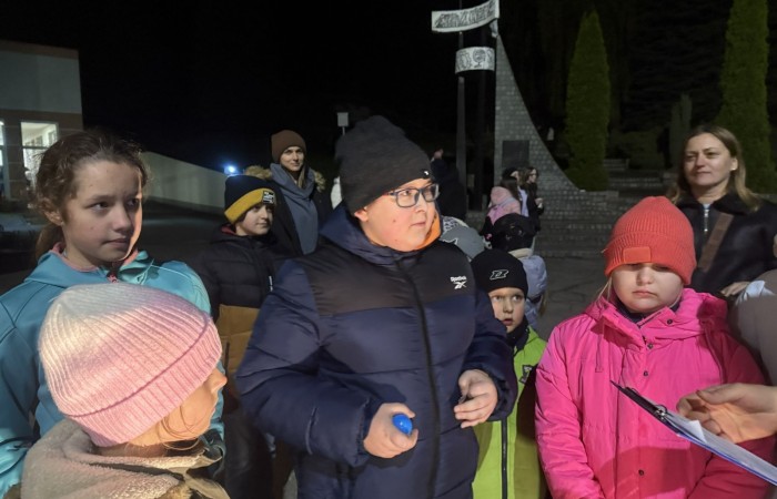 O godzinie 17:00 pod szkołą rozpoczęła się impreza, która zgromadziła około 200 osób. Szkoła została podświetlona na czerwono, co symbolizowało naszą jedność w walce z przemocą. Był to akcent podsumowujący nasze wcześ iej sze  działania w ramach Kampanii Ogólnopolskiej „Dzieciństwo bez Przemocy”. Od października uczniowie uczestniczyli w lekcjach online przygotowanych przez Fundację Dajemy Dzieciom Siłę. Rodzice również zostali objęci wsparciem w postaci webinaru online ww. fudacji.
Uczestnicy mogli wziąć udział w wspólnym śpiewaniu, quizie wiedzy o przemocy oraz tworzeniu „kamieni mocy” – symboli pozytywnej energii i wsparcia. Dodatkowo, w ramach konkursów, przyznano nagrody ufundowane przez Urząd Miejski w Pasłęku.
Ten cudowny czas umilił nam smaczny poczęstunek, w tym grochówka, pizza i ciasta, gorąca kawa i herbatka przygotowany przez panie kucharki i rodziców.
W wydarzeniu uczestniczyli również zaproszeni goście, w tym Burmistrz Pasłęka – pani Elżbieta Wasiuk,  podinspektor KP Pasłęk – pani Agnieszka Bielewicz - Piechowiak oraz przedstawiciel Kuratorium Oświaty w Elblągu – pani Teresa Bednarz, którzy wspierają nasze działania. Ich obecność była dowodem na to, jak ważna jest współpraca lokalnej społeczności w walce z przemocą wobec dzieci. Dziękujemy wszystkim, którzy wzięli udział w tym wyjątkowym dniu oraz przyczynili się do jego organizacji. Razem możemy stworzyć bezpieczne i przyjazne środowisko dla naszych dzieci!
