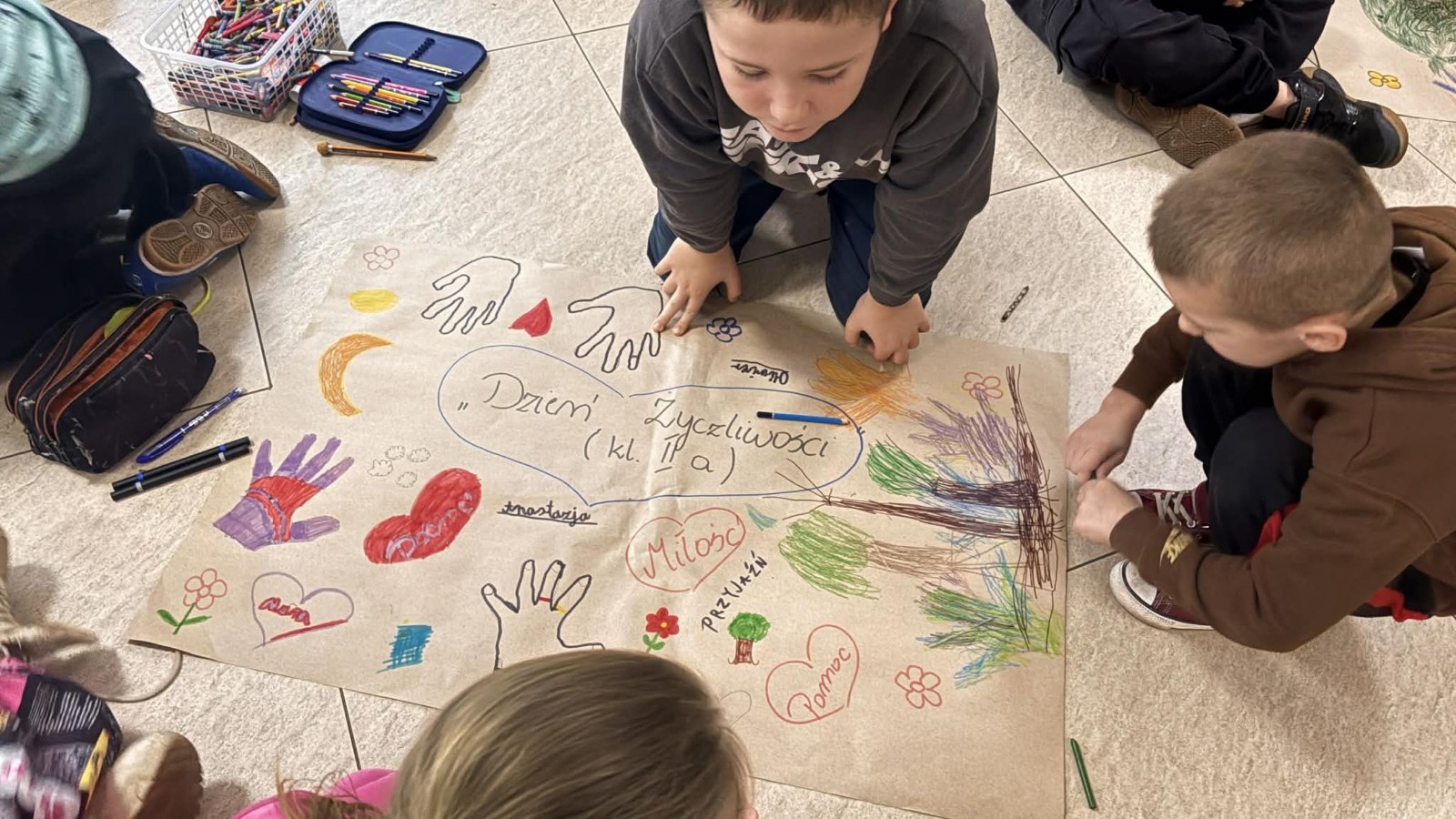 21 listopada uczniowie klas I-III obchodzili Dzień Życzliwości – wyjątkowe święto, które przypomina nam, jak wielką moc mają dobre słowa, uśmiech i drobne gesty. Tego dnia rozmawialiśmy o tym, czym jest życzliwość i jak możemy okazywać ją sobie nawzajem. Uczniowie brali udział w zabawach i aktywnościach promujących dobre relacje, empatię i wzajemny szacunek. Powstało także „drzewko życzliwości”, które już zdobi nasz korytarz i przypomina, że warto być dla siebie dobrym.

Pamiętajmy — życzliwość nic nie kosztuje, a potrafi zdziałać cuda! 