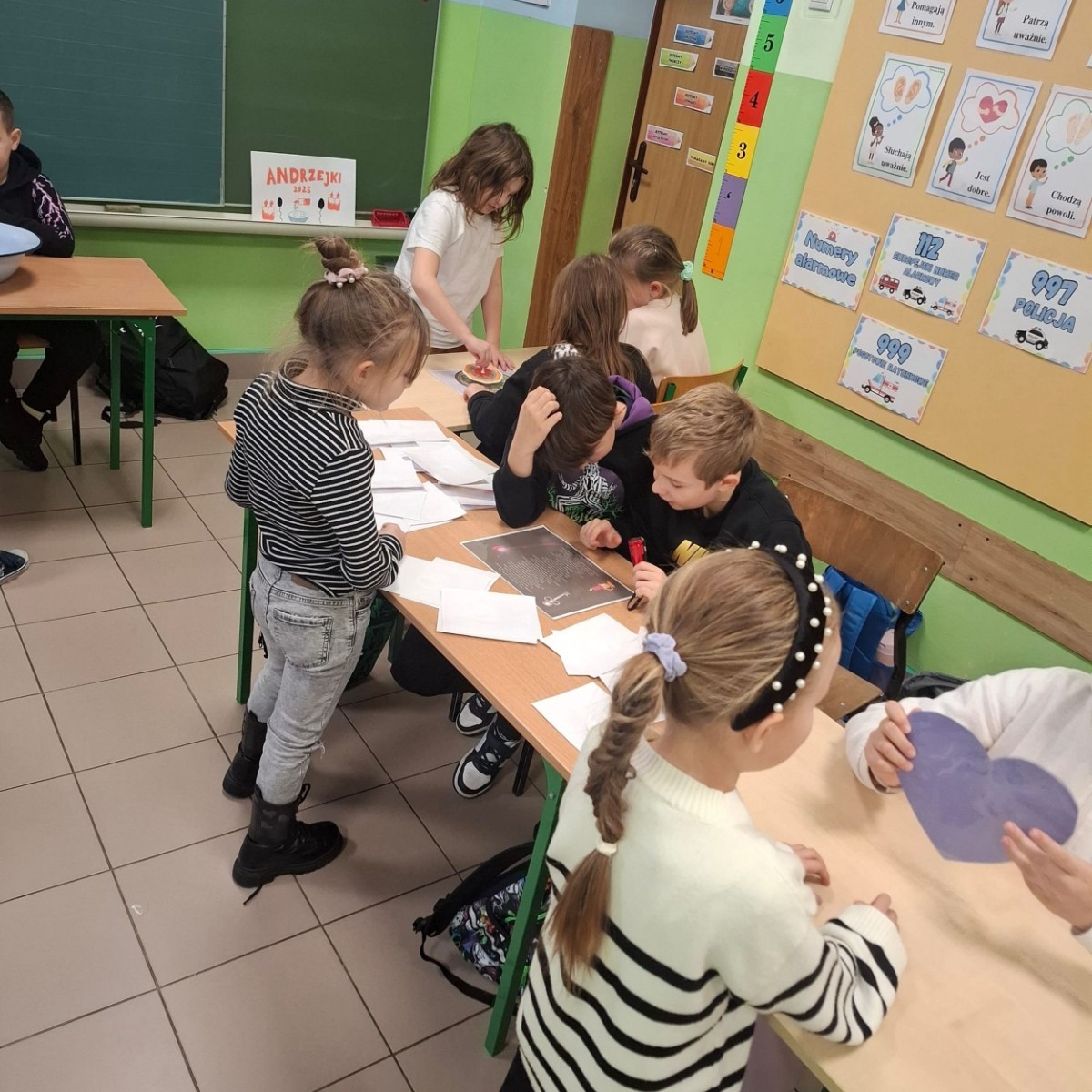 W tym roku Andrzejki w naszej szkole były pełne magii, radości i uśmiechu. Uczniowie klas trzecich przygotowali dla pierwszaków wyjątkowe wróżby i zabawy, dzięki którym mali uczestnicy mogli poczuć prawdziwą andrzejkową atmosferę. Nie zabrakło tradycyjnych wróżb, takich jak serca z imionami, magiczne kubeczki czy karty, a także mnóstwa śmiechu i wspólnej zabawy. Było kolorowo, wesoło i… trochę tajemniczo.
Serdeczne podziękowania dla naszych starszych uczniów za kreatywność i świetną zabawę, a także dla pierwszaków za aktywny udział w andrzejkowych atrakcjach. To był naprawdę magiczny dzień.