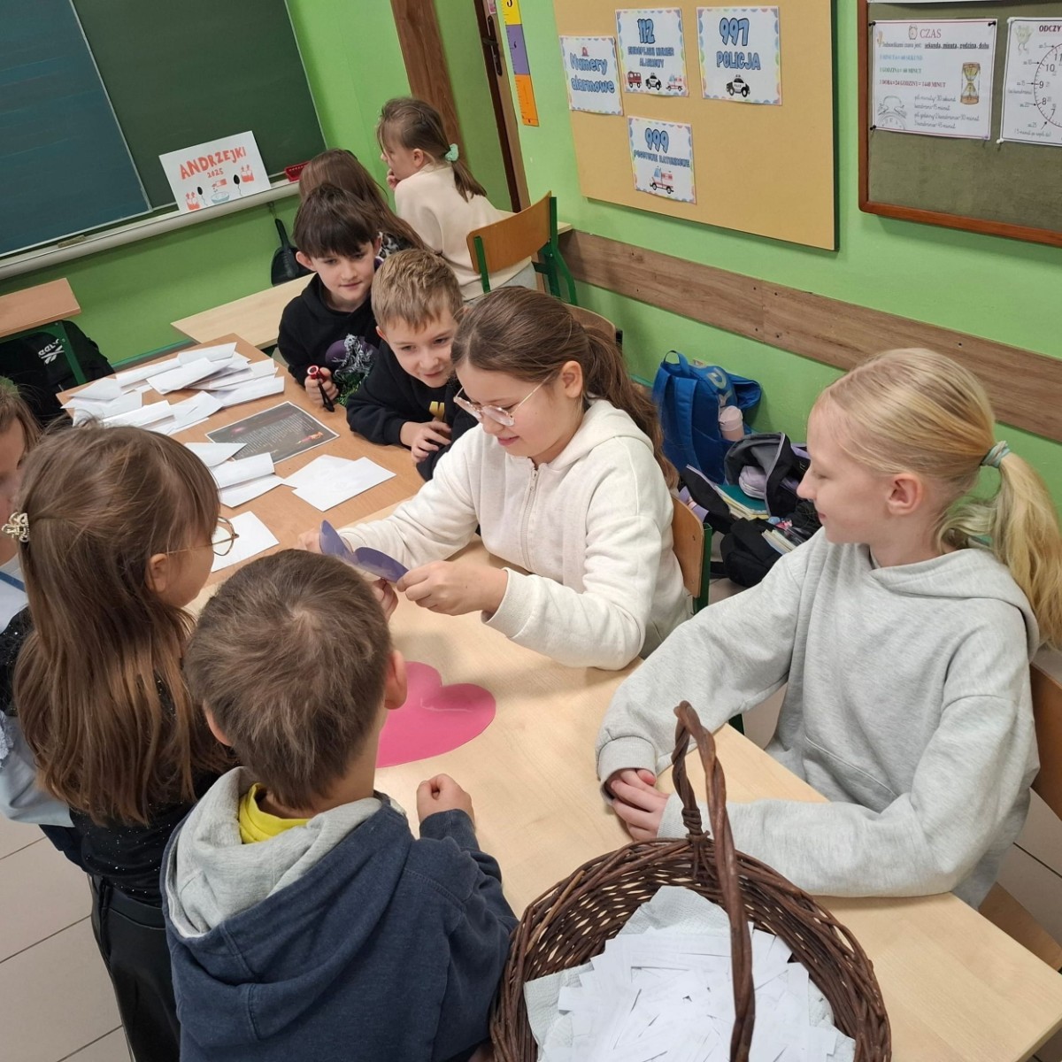 W tym roku Andrzejki w naszej szkole były pełne magii, radości i uśmiechu. Uczniowie klas trzecich przygotowali dla pierwszaków wyjątkowe wróżby i zabawy, dzięki którym mali uczestnicy mogli poczuć prawdziwą andrzejkową atmosferę. Nie zabrakło tradycyjnych wróżb, takich jak serca z imionami, magiczne kubeczki czy karty, a także mnóstwa śmiechu i wspólnej zabawy. Było kolorowo, wesoło i… trochę tajemniczo.
Serdeczne podziękowania dla naszych starszych uczniów za kreatywność i świetną zabawę, a także dla pierwszaków za aktywny udział w andrzejkowych atrakcjach. To był naprawdę magiczny dzień.