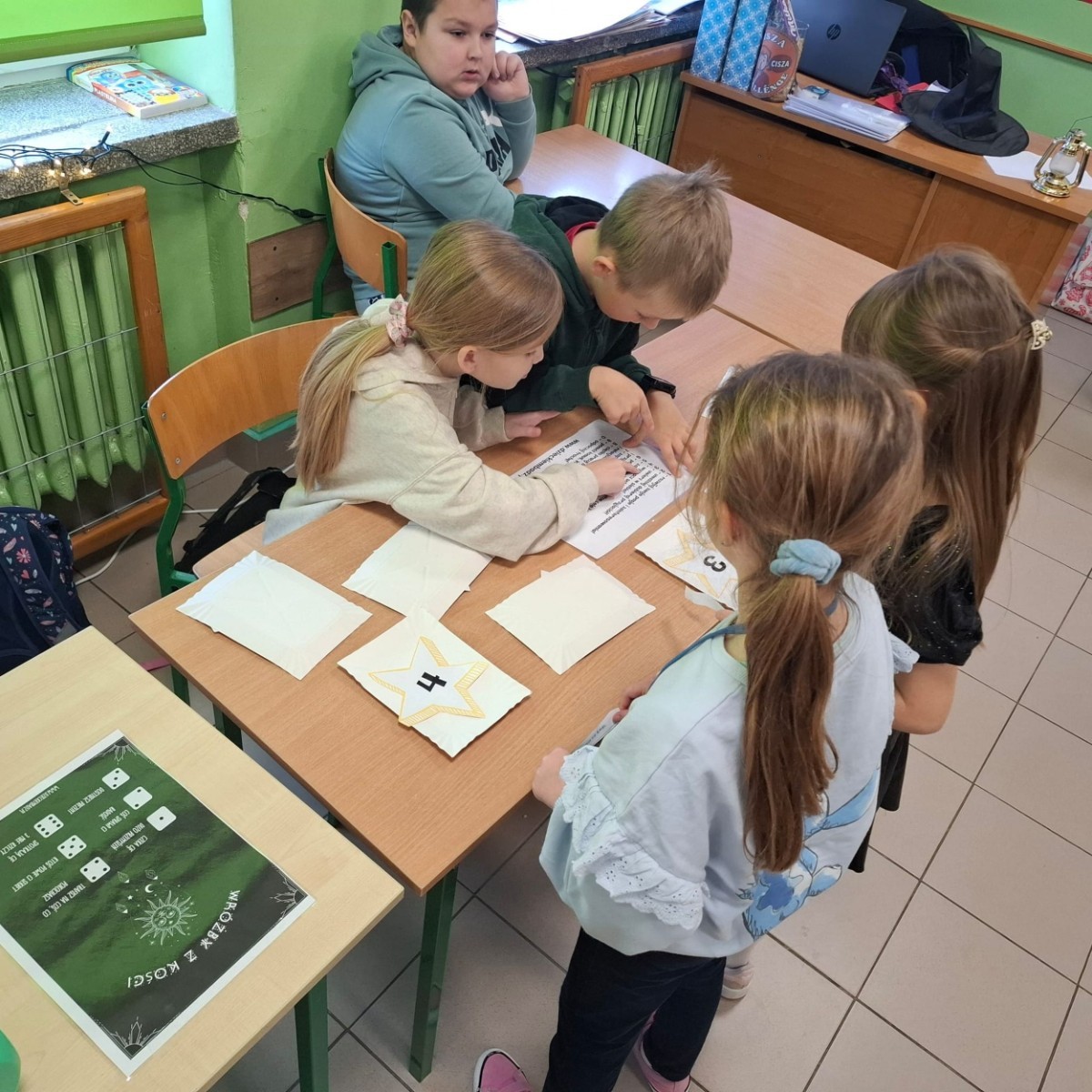 W tym roku Andrzejki w naszej szkole były pełne magii, radości i uśmiechu. Uczniowie klas trzecich przygotowali dla pierwszaków wyjątkowe wróżby i zabawy, dzięki którym mali uczestnicy mogli poczuć prawdziwą andrzejkową atmosferę. Nie zabrakło tradycyjnych wróżb, takich jak serca z imionami, magiczne kubeczki czy karty, a także mnóstwa śmiechu i wspólnej zabawy. Było kolorowo, wesoło i… trochę tajemniczo.
Serdeczne podziękowania dla naszych starszych uczniów za kreatywność i świetną zabawę, a także dla pierwszaków za aktywny udział w andrzejkowych atrakcjach. To był naprawdę magiczny dzień.