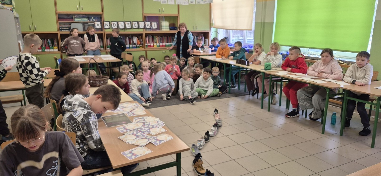 W tym roku Andrzejki w naszej szkole były pełne magii, radości i uśmiechu. Uczniowie klas trzecich przygotowali dla pierwszaków wyjątkowe wróżby i zabawy, dzięki którym mali uczestnicy mogli poczuć prawdziwą andrzejkową atmosferę. Nie zabrakło tradycyjnych wróżb, takich jak serca z imionami, magiczne kubeczki czy karty, a także mnóstwa śmiechu i wspólnej zabawy. Było kolorowo, wesoło i… trochę tajemniczo.
Serdeczne podziękowania dla naszych starszych uczniów za kreatywność i świetną zabawę, a także dla pierwszaków za aktywny udział w andrzejkowych atrakcjach. To był naprawdę magiczny dzień.