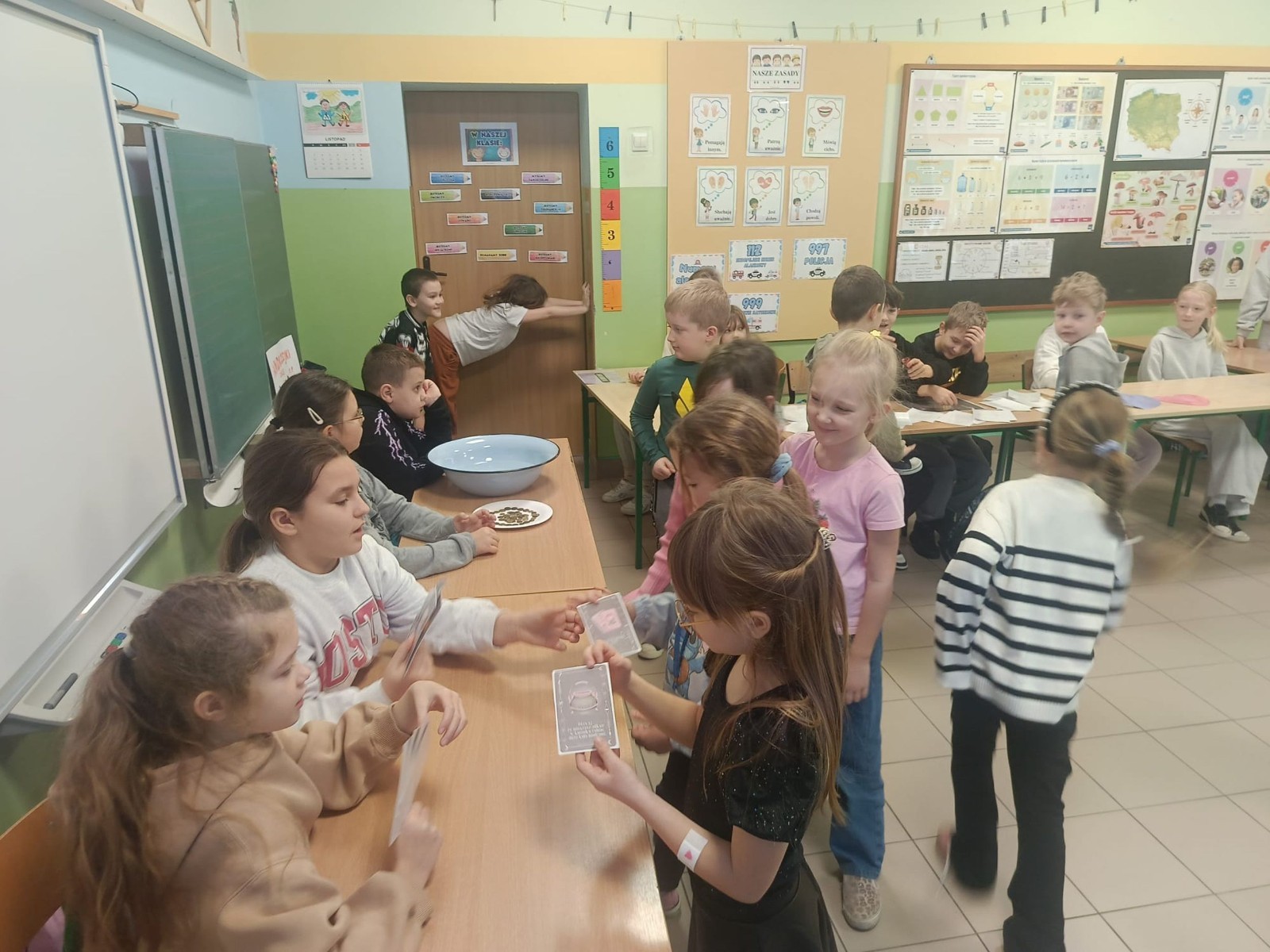 W tym roku Andrzejki w naszej szkole były pełne magii, radości i uśmiechu. Uczniowie klas trzecich przygotowali dla pierwszaków wyjątkowe wróżby i zabawy, dzięki którym mali uczestnicy mogli poczuć prawdziwą andrzejkową atmosferę. Nie zabrakło tradycyjnych wróżb, takich jak serca z imionami, magiczne kubeczki czy karty, a także mnóstwa śmiechu i wspólnej zabawy. Było kolorowo, wesoło i… trochę tajemniczo.
Serdeczne podziękowania dla naszych starszych uczniów za kreatywność i świetną zabawę, a także dla pierwszaków za aktywny udział w andrzejkowych atrakcjach. To był naprawdę magiczny dzień.