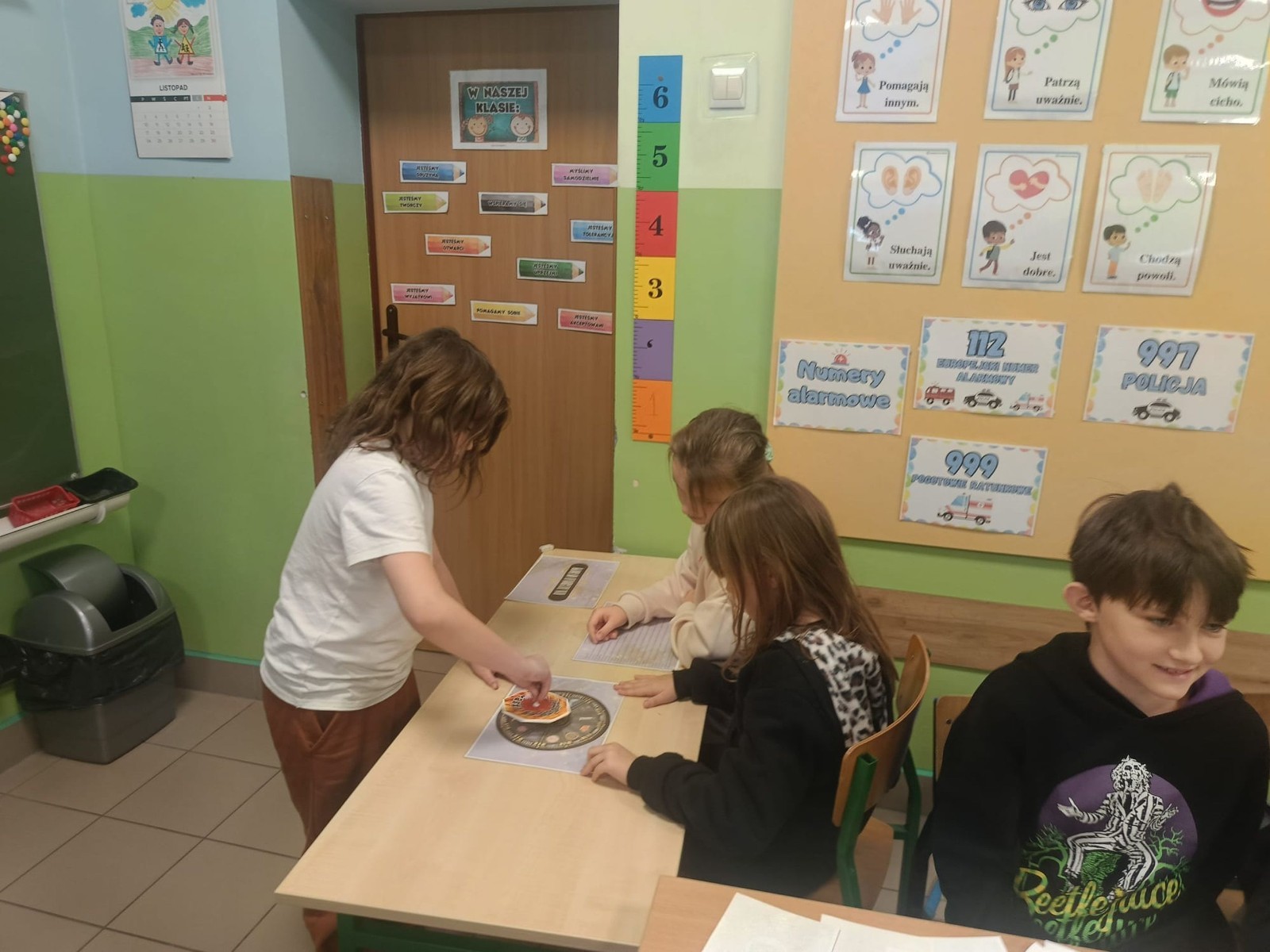 W tym roku Andrzejki w naszej szkole były pełne magii, radości i uśmiechu. Uczniowie klas trzecich przygotowali dla pierwszaków wyjątkowe wróżby i zabawy, dzięki którym mali uczestnicy mogli poczuć prawdziwą andrzejkową atmosferę. Nie zabrakło tradycyjnych wróżb, takich jak serca z imionami, magiczne kubeczki czy karty, a także mnóstwa śmiechu i wspólnej zabawy. Było kolorowo, wesoło i… trochę tajemniczo.
Serdeczne podziękowania dla naszych starszych uczniów za kreatywność i świetną zabawę, a także dla pierwszaków za aktywny udział w andrzejkowych atrakcjach. To był naprawdę magiczny dzień.