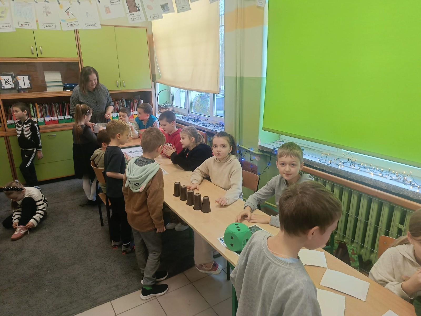 W tym roku Andrzejki w naszej szkole były pełne magii, radości i uśmiechu. Uczniowie klas trzecich przygotowali dla pierwszaków wyjątkowe wróżby i zabawy, dzięki którym mali uczestnicy mogli poczuć prawdziwą andrzejkową atmosferę. Nie zabrakło tradycyjnych wróżb, takich jak serca z imionami, magiczne kubeczki czy karty, a także mnóstwa śmiechu i wspólnej zabawy. Było kolorowo, wesoło i… trochę tajemniczo.
Serdeczne podziękowania dla naszych starszych uczniów za kreatywność i świetną zabawę, a także dla pierwszaków za aktywny udział w andrzejkowych atrakcjach. To był naprawdę magiczny dzień.