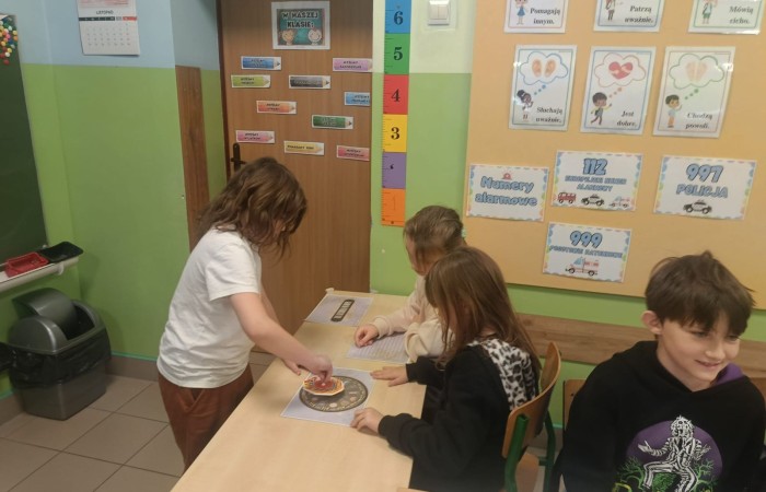 W tym roku Andrzejki w naszej szkole były pełne magii, radości i uśmiechu. Uczniowie klas trzecich przygotowali dla pierwszaków wyjątkowe wróżby i zabawy, dzięki którym mali uczestnicy mogli poczuć prawdziwą andrzejkową atmosferę. Nie zabrakło tradycyjnych wróżb, takich jak serca z imionami, magiczne kubeczki czy karty, a także mnóstwa śmiechu i wspólnej zabawy. Było kolorowo, wesoło i… trochę tajemniczo.
Serdeczne podziękowania dla naszych starszych uczniów za kreatywność i świetną zabawę, a także dla pierwszaków za aktywny udział w andrzejkowych atrakcjach. To był naprawdę magiczny dzień.