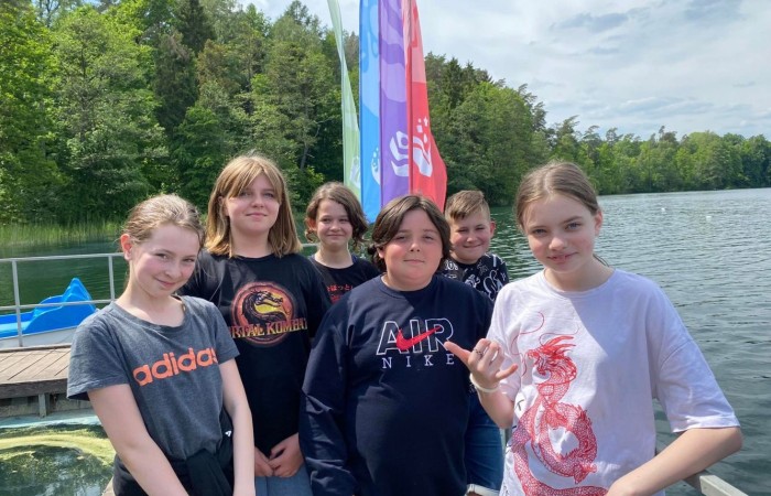 W poniedziałek 6 czerwca 2022 r. uczniowie z klasy Va i Vb  byli na wycieczce w Ośrodku KULKA. Jest to wymarzone miejsce dla tych, którzy uwielbiają dobrą zabawę i wypoczynek w otoczeniu natury, nad pięknym jeziorem Łęsk. Jednym z punktów programu był park linowy. Piątoklasiści bez problemu pokonali dwa tory, które wymagały zręczności i uwagi. Było kodowanie według klucza ENIGMA, strzelanie z łuków oraz granie w popularne na świecie gry zręcznościowe. Był czas na lody, słodkie przekąski oraz odpoczynek w promieniach ciepłego słońca.